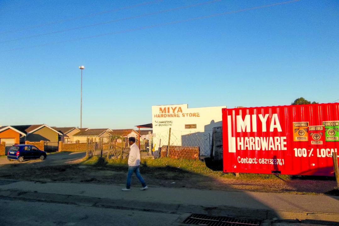 A pedestrian walks past the Miya hardware store in Joza. The store has been running for the past 20 years. © Siphamandla Boma.