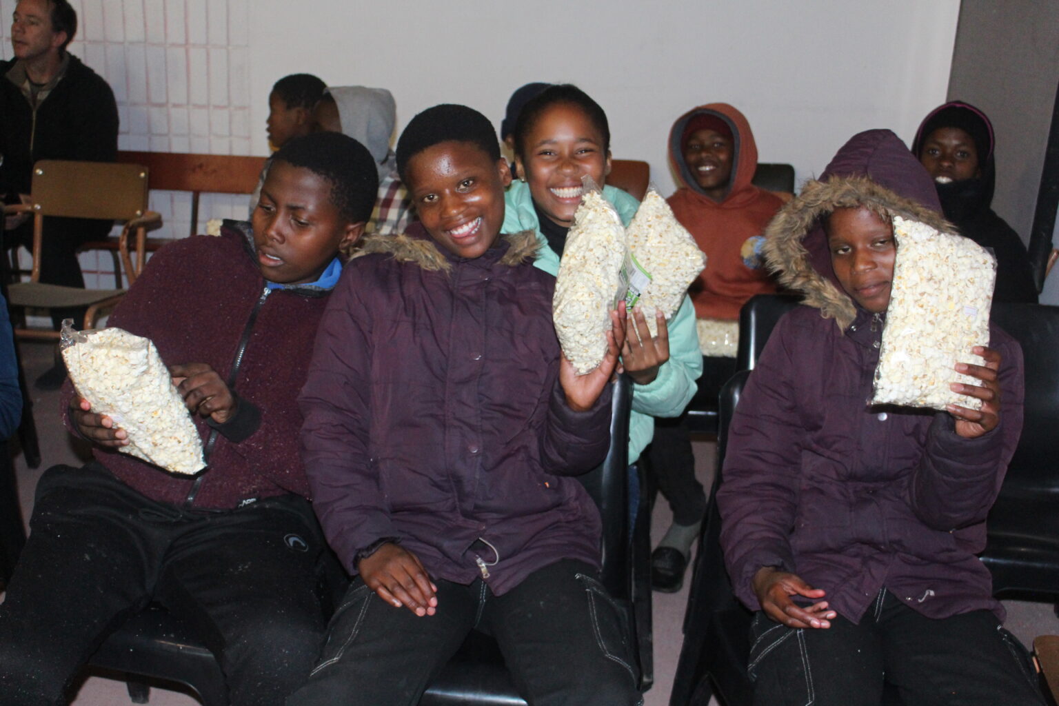 Children enjoy popcorn before the start of a locally produce film. Photo_ Ovayo Milisa Novukela