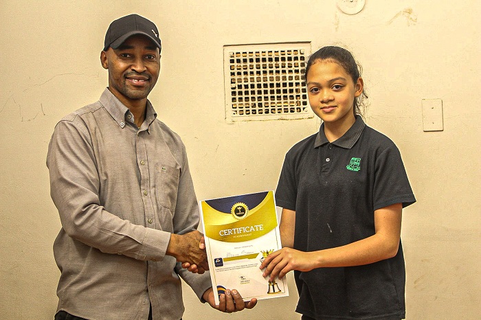 Sarah Moller from Victoria Girls Primary awarded a Chess Certificate by Coach Jeremiah Sewelo.