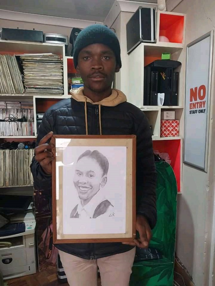 A business owner, and artist, Lubabalo Kosi holding a portrait of Leleti Khumalo.