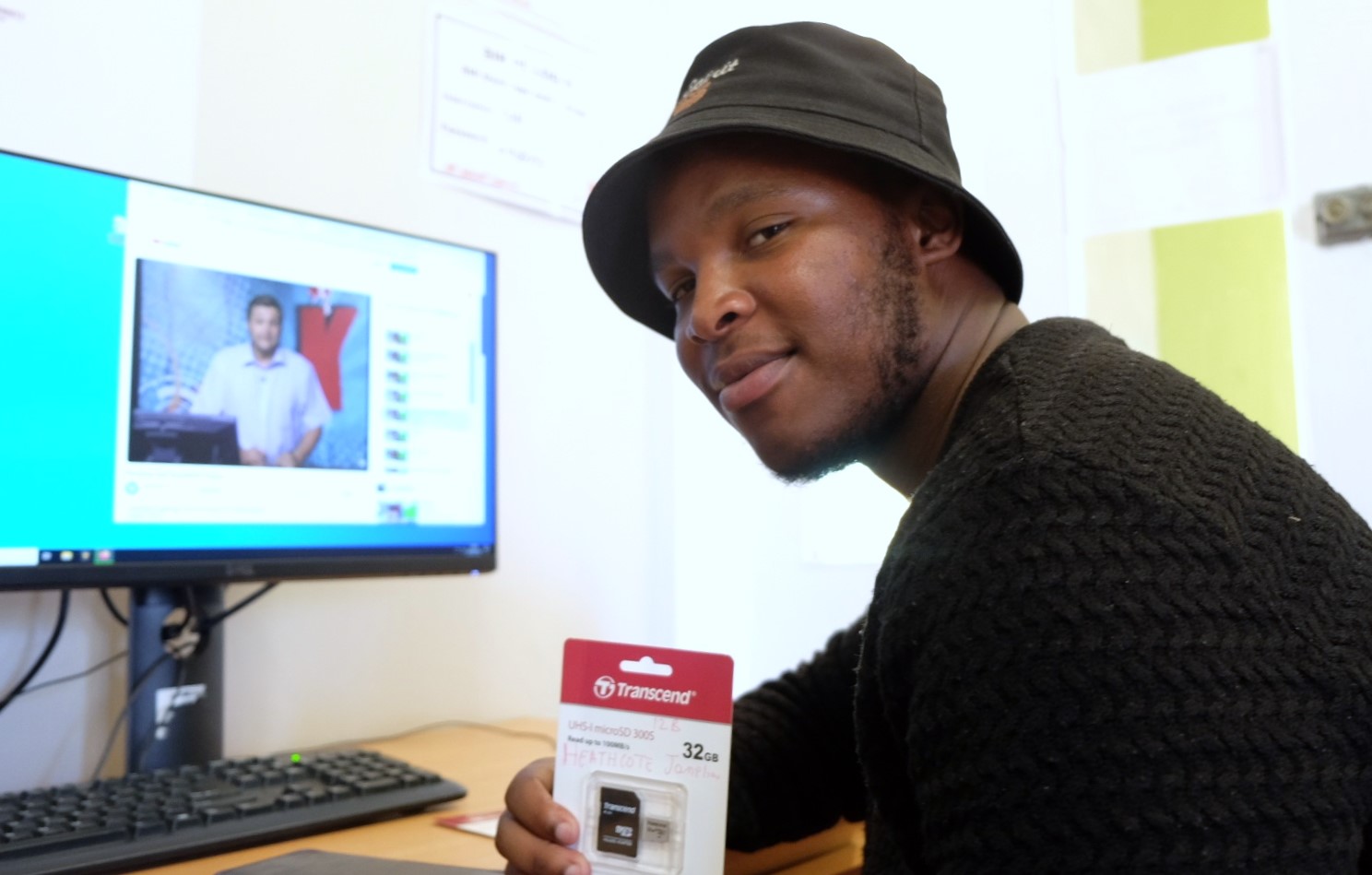 Social Employment Fund (SEF) worker Aphiwe shows off an SD card at the Social Innovation Hub at the Rhodes University Community Engagement centre. Photo: Rod Amner