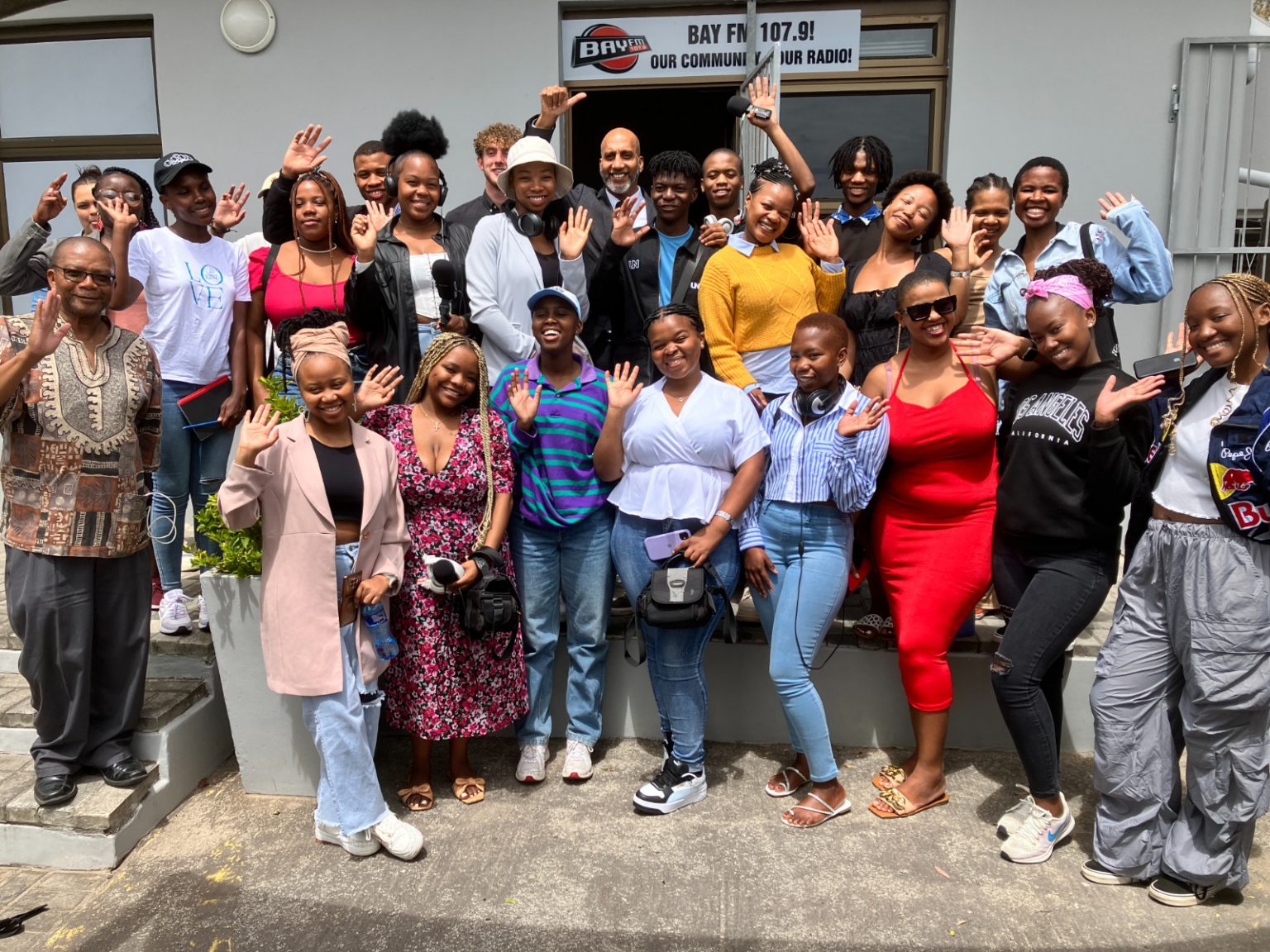 Third year audio students of Rhodes Journalism and Media Studies class are joined by their lecturer, Shepi Mati (far left) and breakfast show host, Jason Gabriel (centre with beard) in front of Bay FM studios in Gqeberha. Photo: Steven Lang