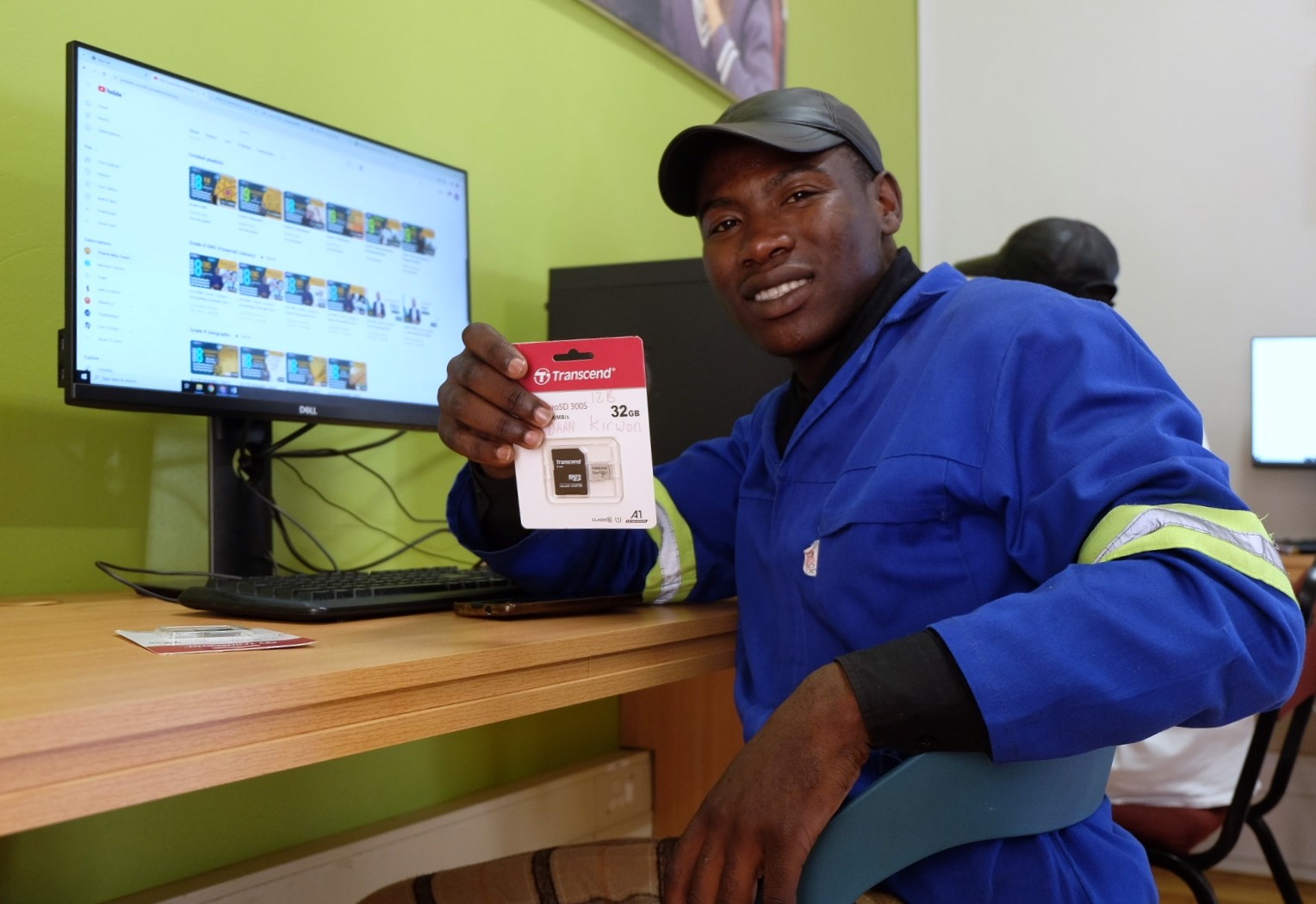 Social Employment Fund (SEF) worker Kamvelihle Gule shows off an SD card at the Social Innovation Hub at the Rhodes University Community Engagement centre. Photo: Rod Amner