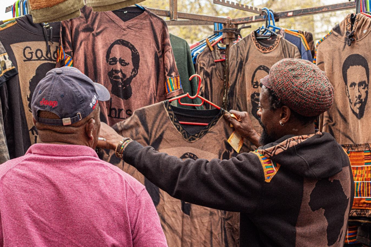 An eager tourist makes a purchase at Isaias’ clothing stall on High Street in the CBD of Makhanda. Photo: Siqhamo Jama