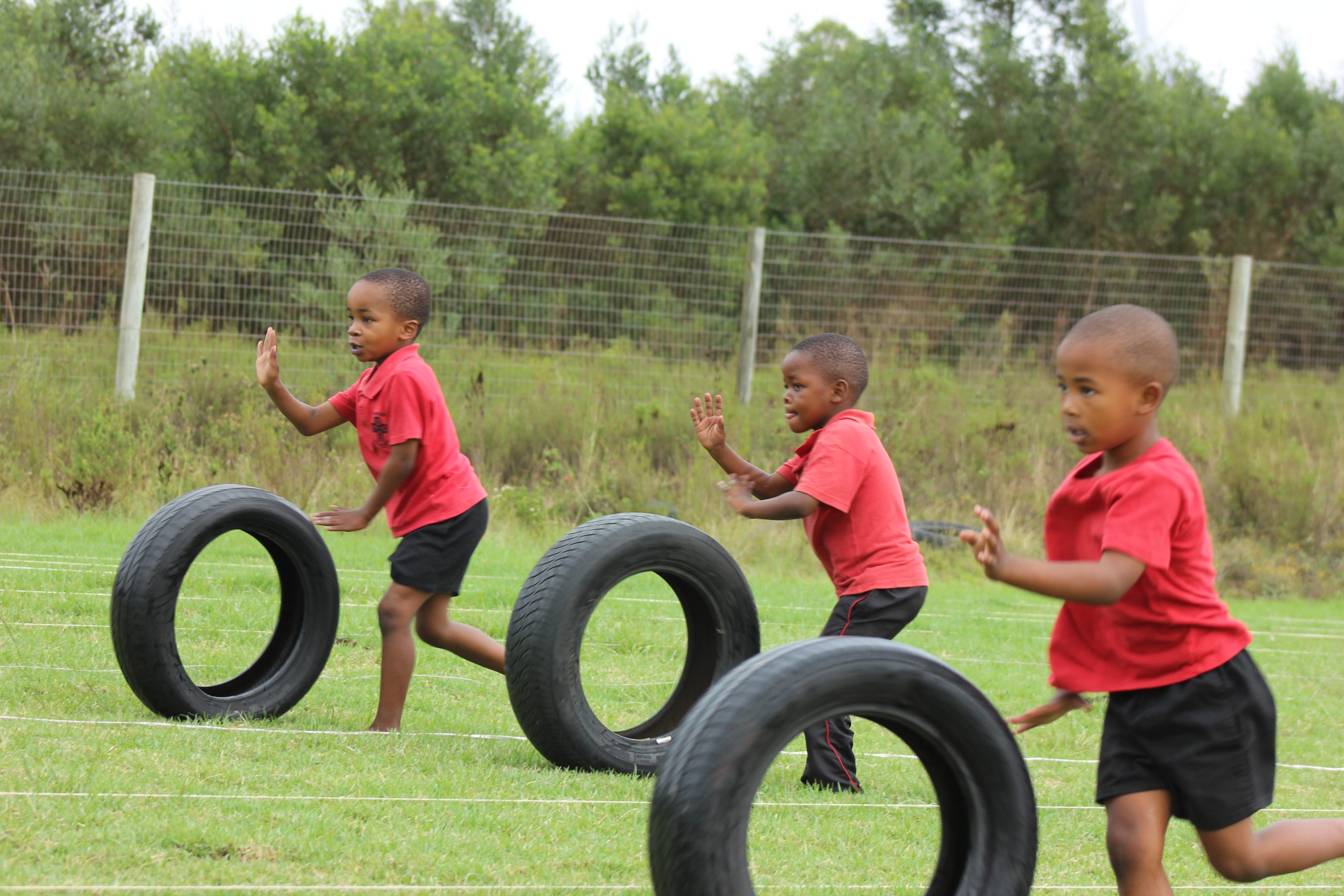 Holy Cross learners participating in tyre chasing on sports day. Photo: supplied