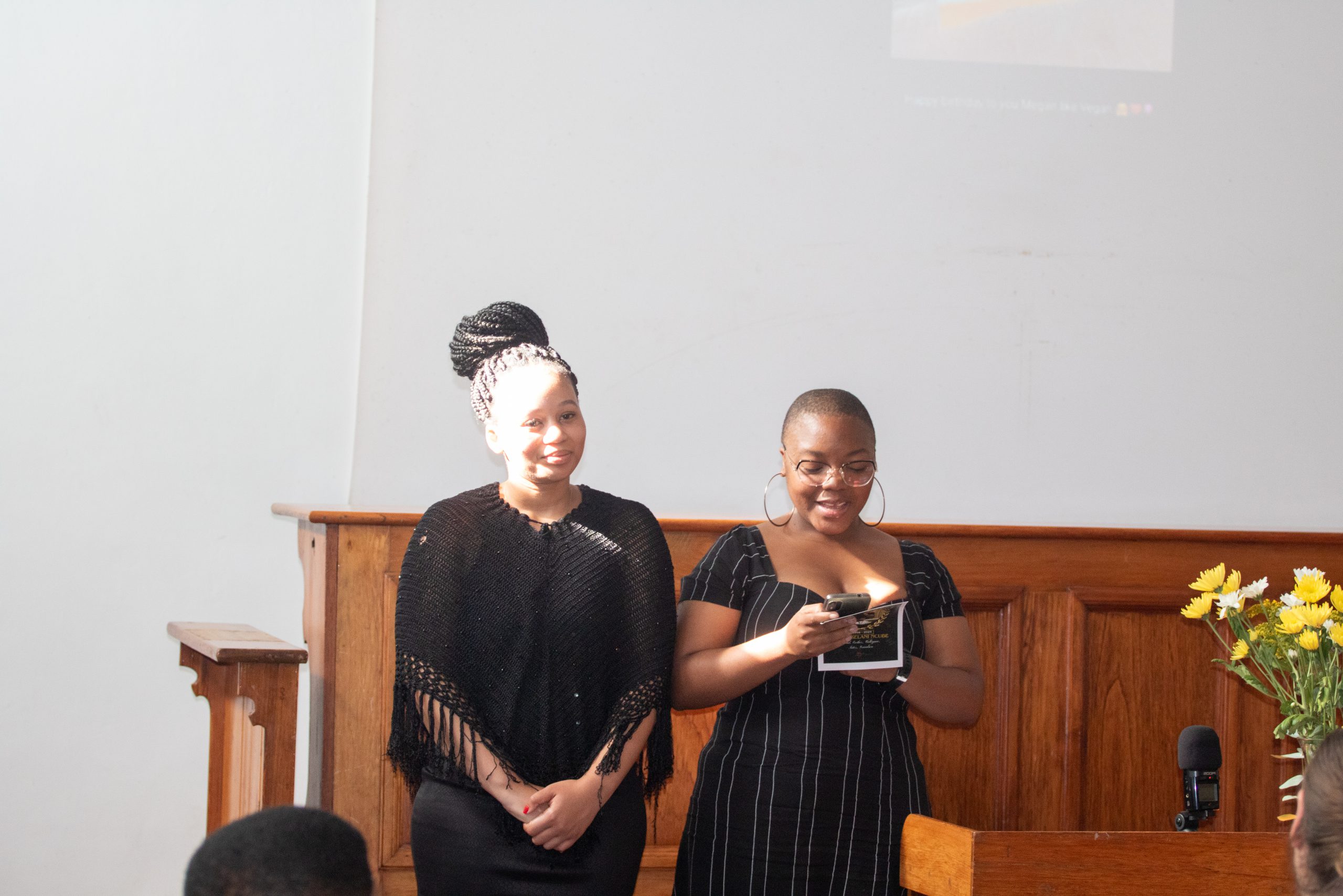 Thato Mckade (left) and Tiisetso Kwanda Nhlapho (right) reading tributes from Thembelani's friends, family, and classmates. Photo: Linda Pona