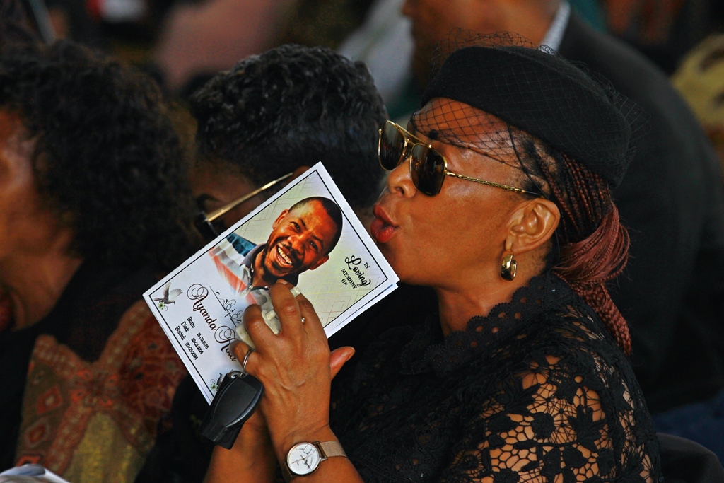 A family member mourns the passing of Ayanda Kota as she clasps the programme of the funeral service. Photo: Steven Lang