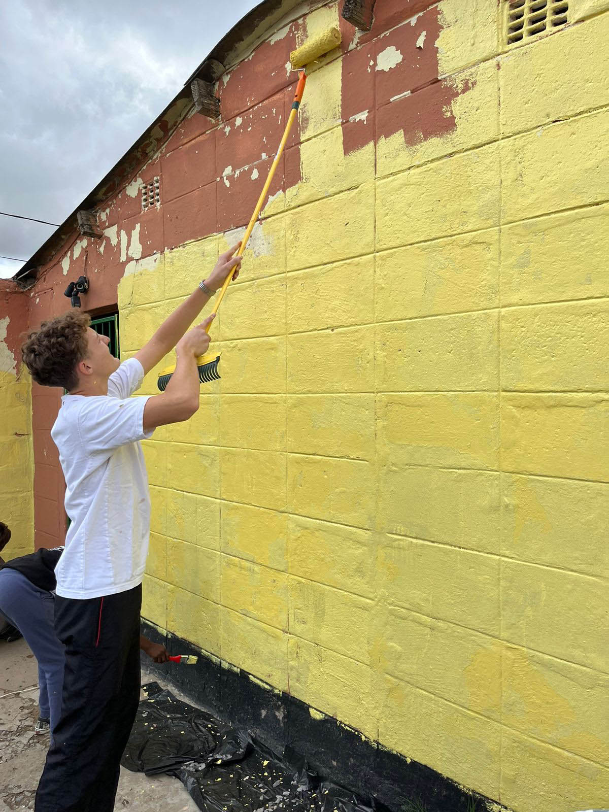 Aiden Knott helps paint a house during Make a Difference Day. Photo: Jackie Clausen