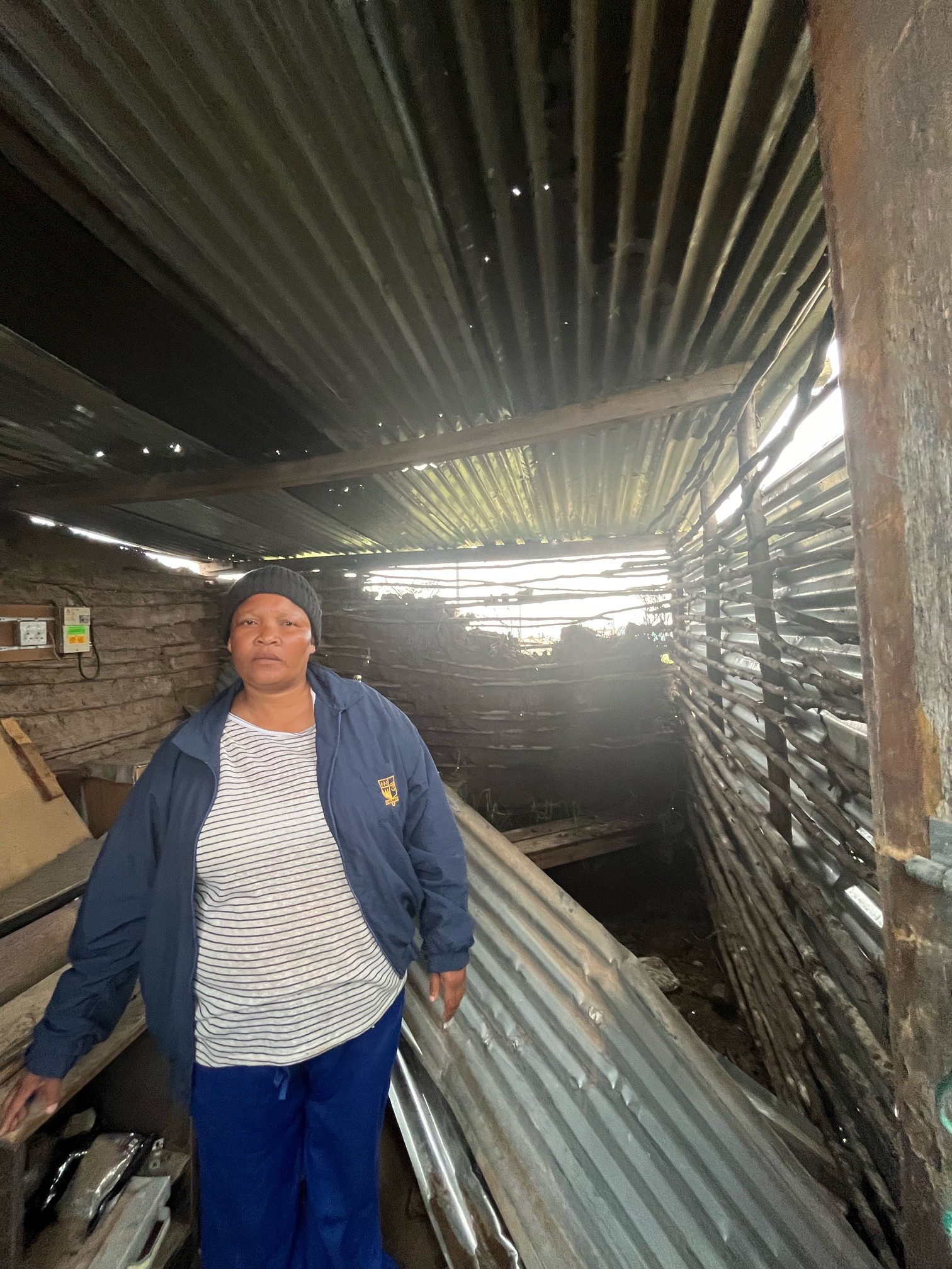 Member of a displaced family Sta ding in ruins cause by terrible winds and rain Photo by Phila-Nathi Mapisa