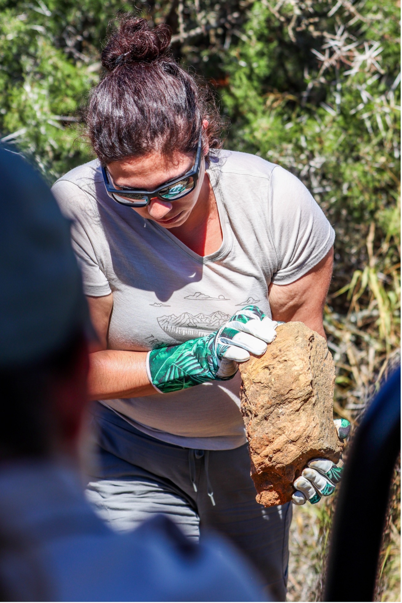 Dressed in comfortable clothes and equipped with garden gloves to protect their hands, the volunteers collect large rocks to use to fix the fence. Photo: Abigail Van der Hoven