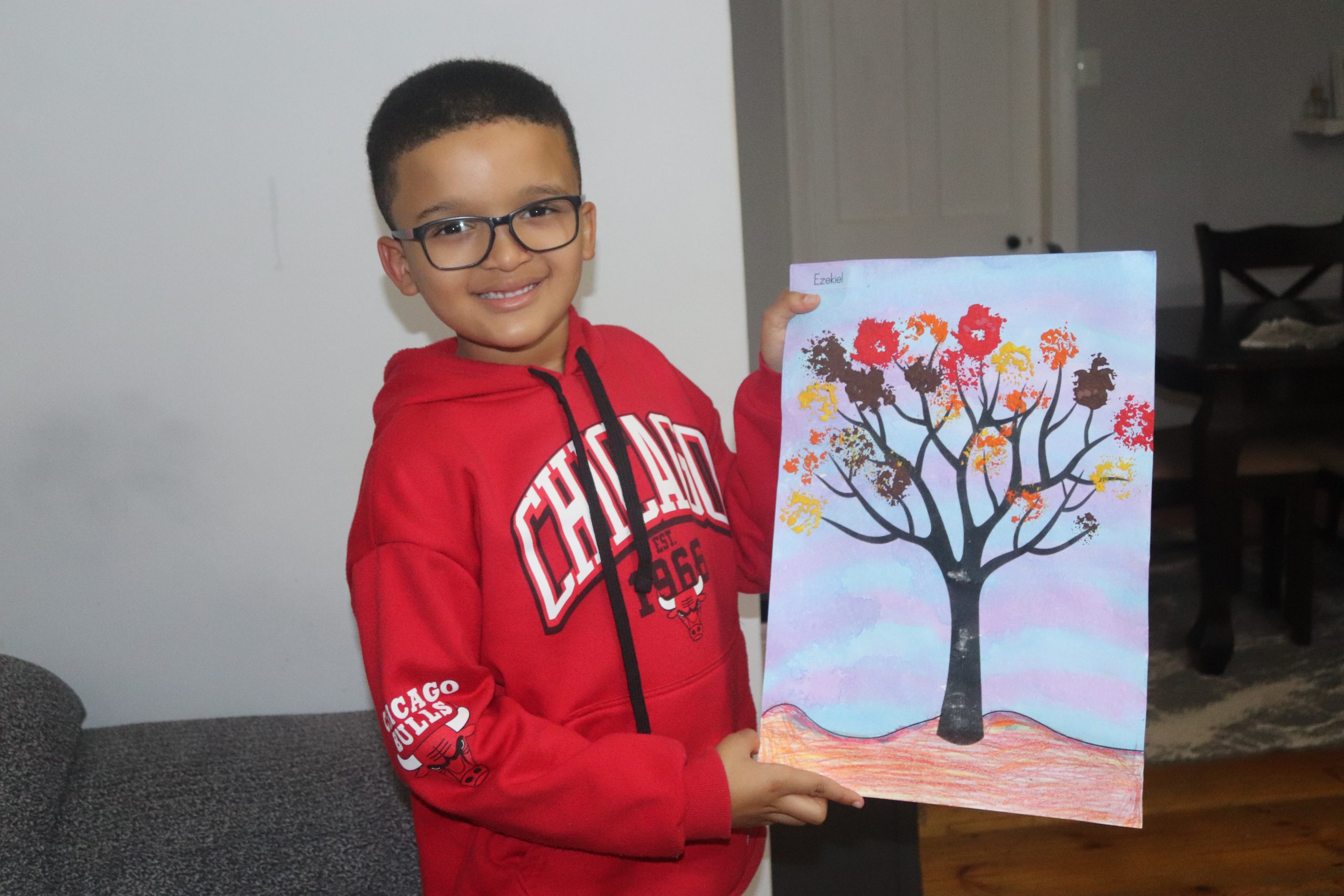 Ezekiel Jewell holding a painting he designed at the age of 5 years at his home, 30 May 2024. Photo: Khanyisa Khenese.