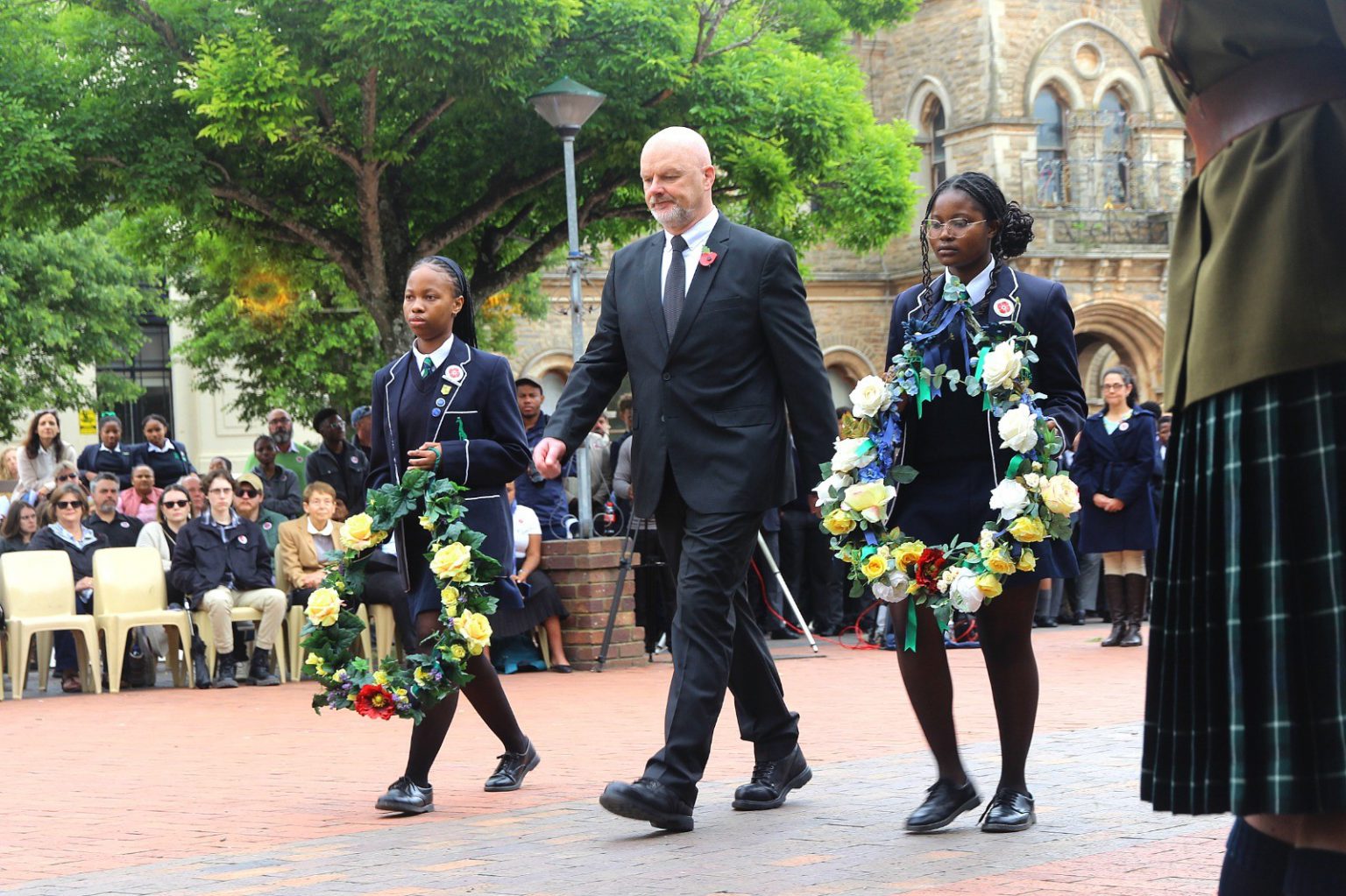 Victoria Girls High School principal, Warren Schmidt, flanked by two senior pupils, about to lay wreaths from the school on the steps of the cenotaph on Church Square. Photo: Steven Lang