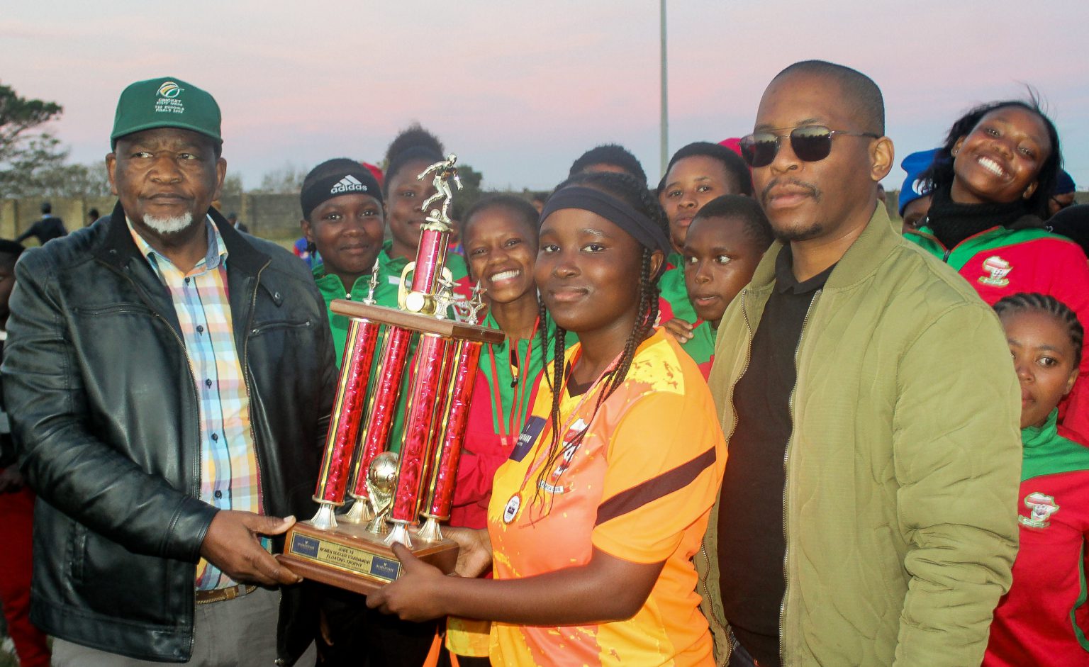 Women’s football takes centre stage on Youth Day Makana ward councillor Ramie Xonxa (left) hands over the winners' trophy to African Connection Women's Football Club's Zintle Siwa after the Makhanda side were crowned the June 16 Women Soccer Tournament at JD Dlepu Stadium this past weekend. An official from Ibhabhathane looks on. Photo: Chris Totobela