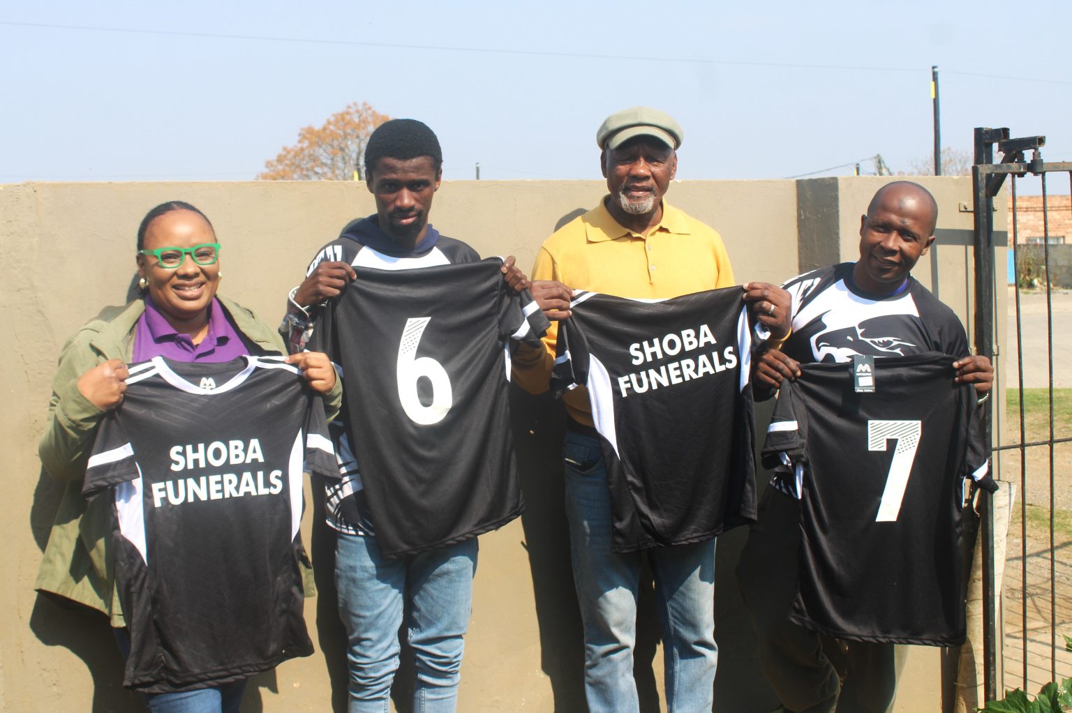 Nomampondomise Shoba (left) and her father, Mthuthuzeli Shoba (second from right), hand over a kit donation to XI Attackers FC's Sihle Ntlanjeni and Luyolo Ngcungca. Photo: Chris Totobela