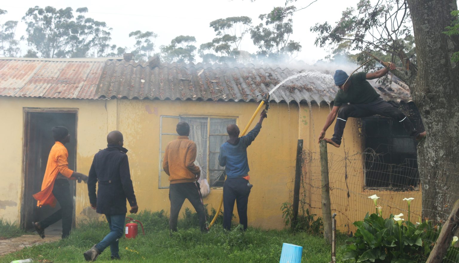 Ncame Street residents fight a fire that killed a 37-year-old man in the area this morning. Photo: Luvuyo Mjekula